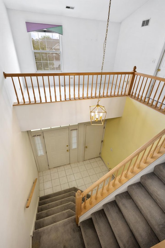 1985 Blackberry Ln Unit 1985, Hoffman Estates, IL 60169 - staircase featuring a chandelier, a high ceiling, and tile patterned flooring