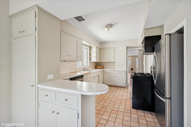 4212 N Central Park Ave, Chicago, IL 60618 - kitchen featuring appliances with stainless steel finishes, a sink, a peninsula, backsplash, and light countertops