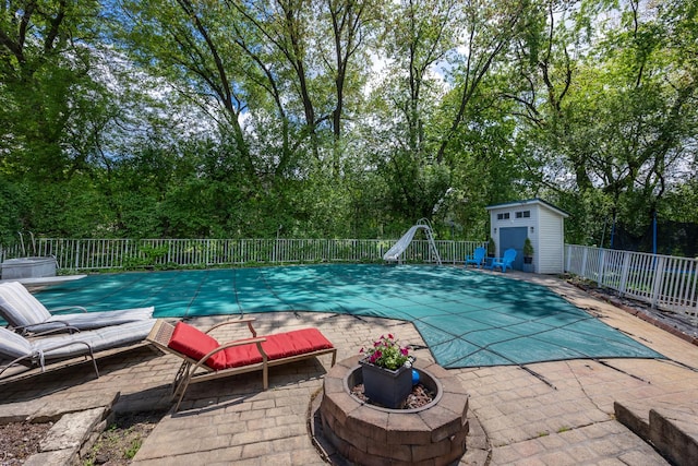 1723 Columbine Dr, Schaumburg, IL 60173 - view of pool featuring a water slide, a patio area, a fire pit, and view of wooded area