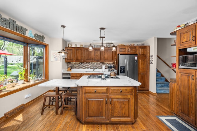 1723 Columbine Dr, Schaumburg, IL 60173 - kitchen featuring appliances with stainless steel finishes, wood finished floors, tasteful backsplash, and brown cabinets