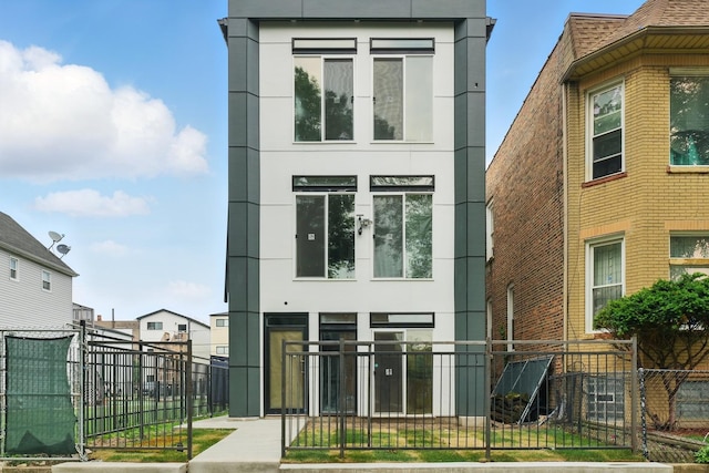 contemporary house featuring a fenced front yard and stucco siding