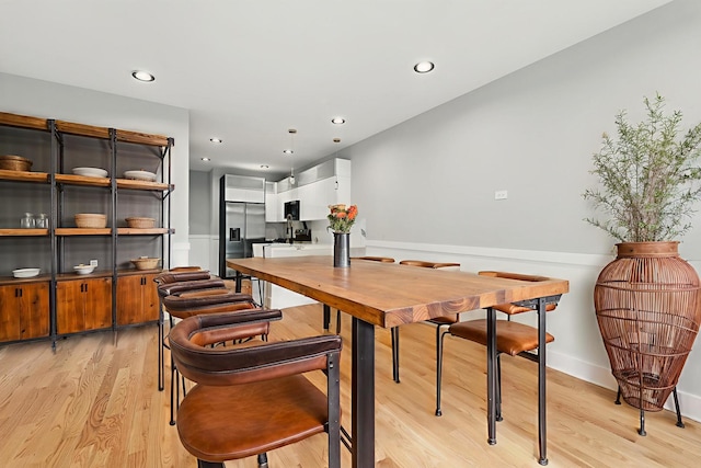 dining space with light wood finished floors and recessed lighting