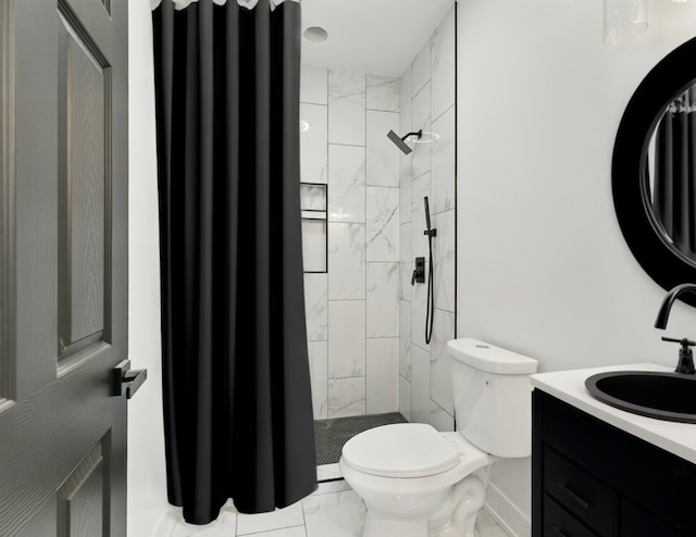 bathroom with marble look tile flooring, vanity, and tiled shower