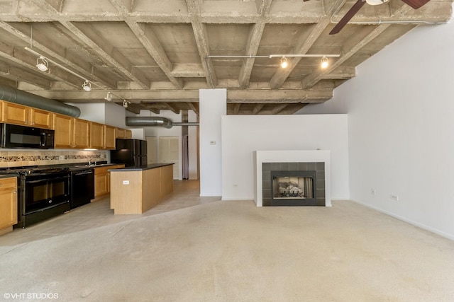 5200 S Ellis Ave Unit 211, Chicago, IL 60615 - kitchen with black appliances, open floor plan, dark countertops, a tiled fireplace, and a center island