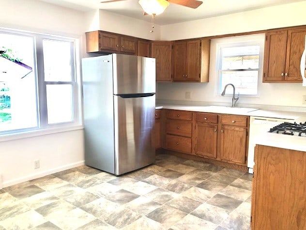 kitchen with freestanding refrigerator, healthy amount of natural light, ceiling fan, and light countertops