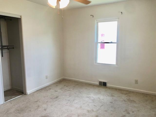 unfurnished bedroom featuring carpet, baseboards, and a ceiling fan