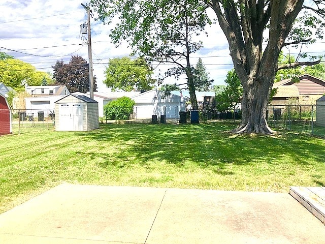 view of yard featuring a patio, a storage shed, and an outdoor structure