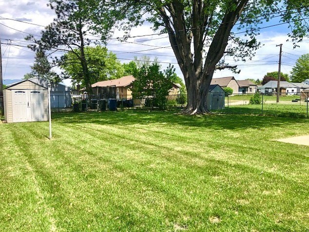 view of yard with a storage shed, an outdoor structure, and a residential view