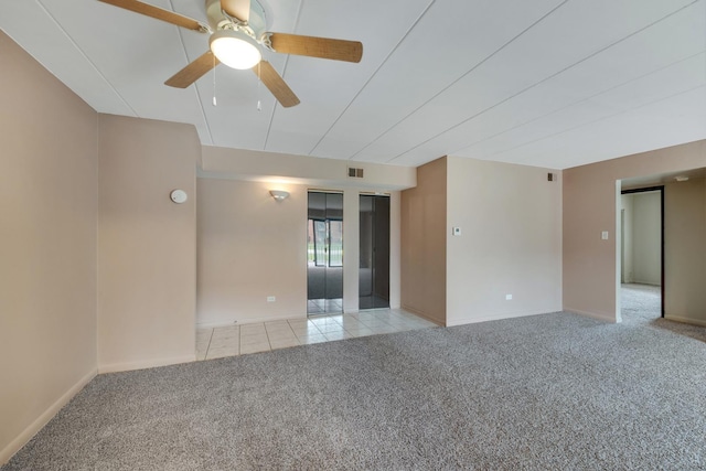 tiled spare room with carpet, ceiling fan, and baseboards