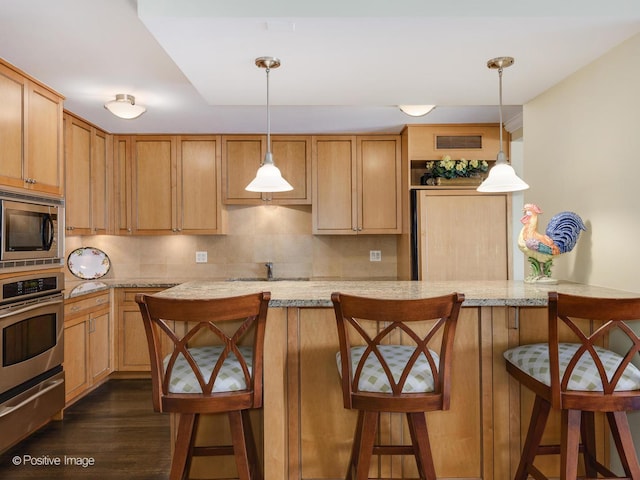 1212 N Lake Shore Dr Unit 12Cn, Chicago, IL 60610 - kitchen with appliances with stainless steel finishes, a warming drawer, a breakfast bar, dark wood-type flooring, and hanging light fixtures