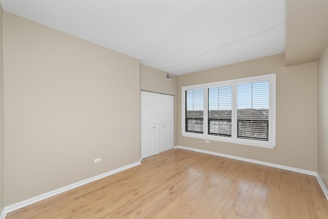 6420 Double Eagle Dr Unit 512, Woodridge, IL 60517 - unfurnished bedroom featuring baseboards, light wood-type flooring, and a closet