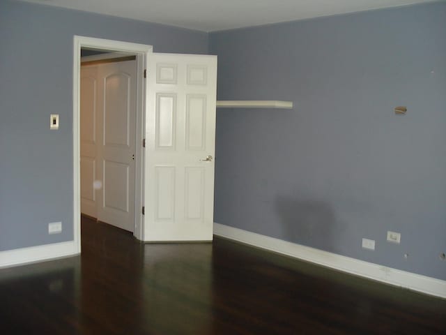 spare room featuring wood finished floors and baseboards