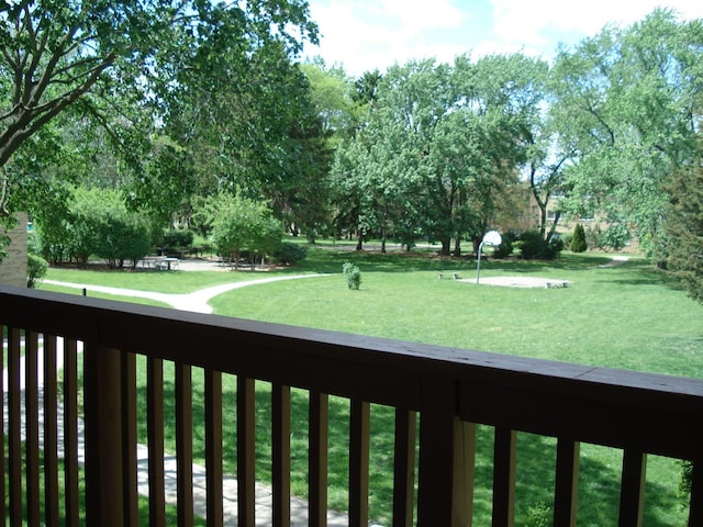 view of grassy yard featuring a balcony