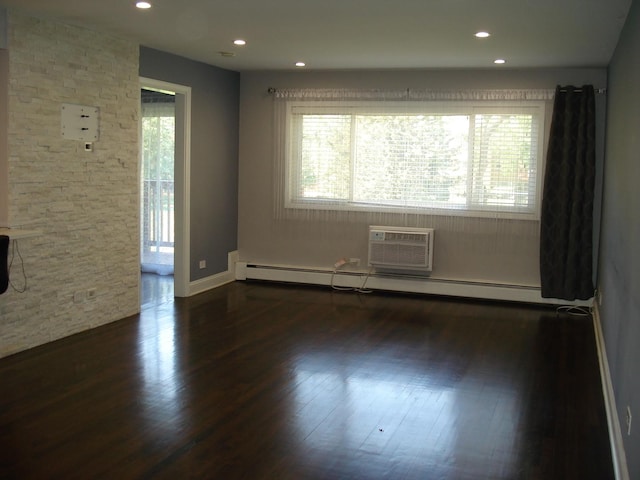 unfurnished room with dark wood-style floors, baseboard heating, an AC wall unit, recessed lighting, and baseboards