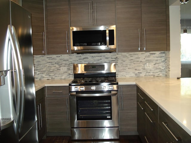 kitchen featuring appliances with stainless steel finishes, light countertops, decorative backsplash, and dark brown cabinets