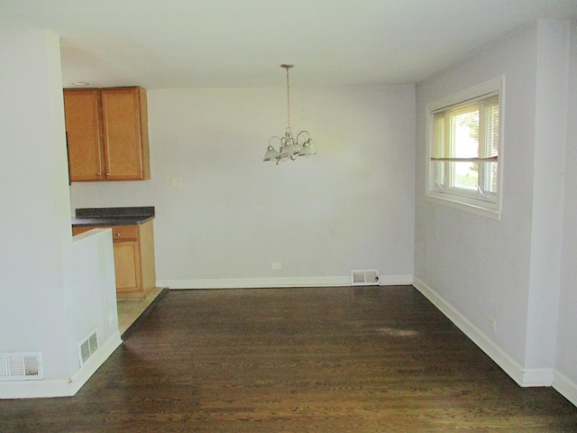 9029 S Crandon Ave, Chicago, IL 60617 - unfurnished dining area featuring a chandelier, dark wood-type flooring, and baseboards