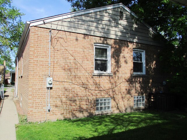 9029 S Crandon Ave, Chicago, IL 60617 - view of home's exterior featuring brick siding and a yard