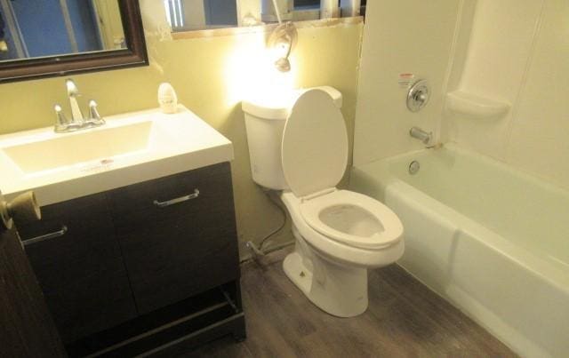 full bath with wood finished floors, toilet, vanity, and tub / shower combination