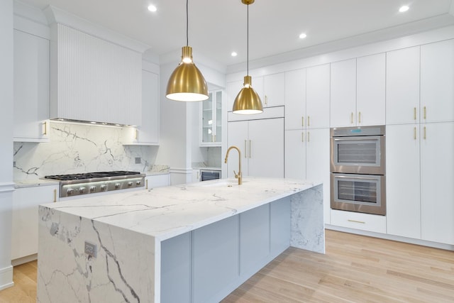 2535 W Belden Ave, Chicago, IL 60647 - kitchen featuring paneled built in fridge, a sink, stainless steel double oven, backsplash, and light wood-type flooring