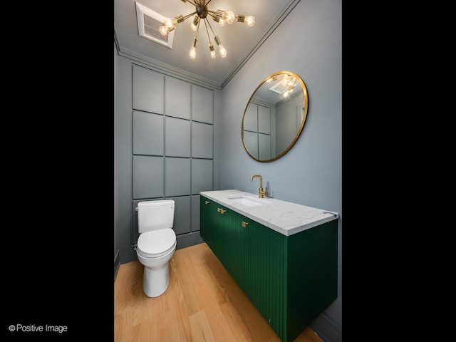 2535 W Belden Ave, Chicago, IL 60647 - bathroom with wood finished floors, a chandelier, toilet, vanity, and crown molding