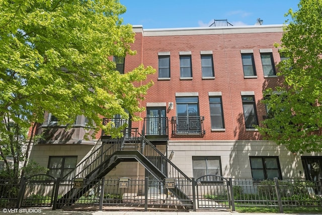 view of building exterior featuring a fenced front yard and stairs