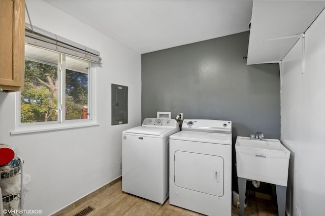 812 Sumac Dr, Streamwood, IL 60107 - clothes washing area featuring washing machine and dryer, electric panel, cabinet space, and light wood-style floors