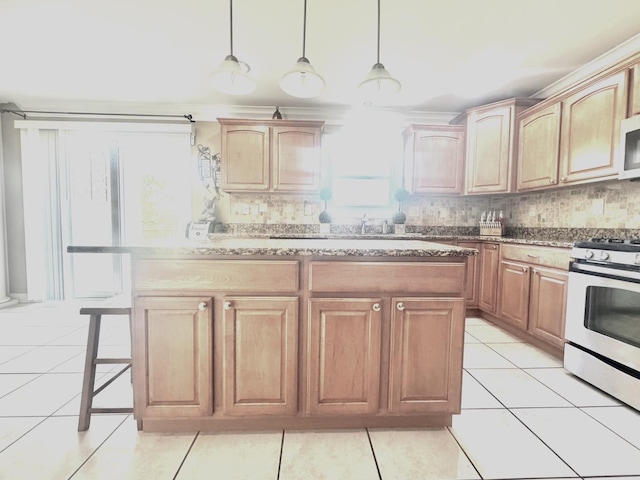 8834 Doubletree Dr N, Crown Point, IN 46307 - kitchen featuring gas stove, tasteful backsplash, a breakfast bar, a kitchen island, and hanging light fixtures