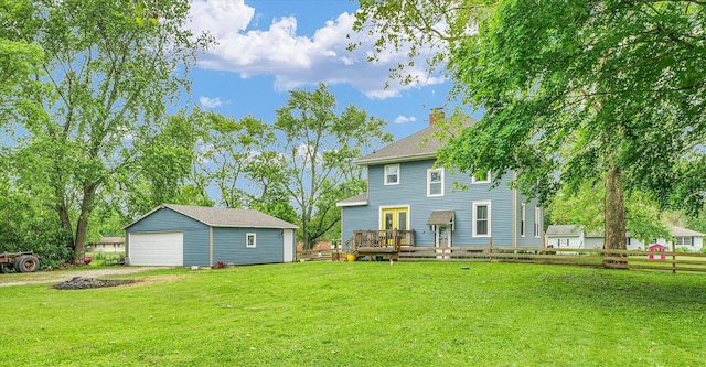 512 S Scarborough St, Sidney, IL 61877 - back of property featuring an outbuilding, a chimney, a garage, a deck, and a shingled roof