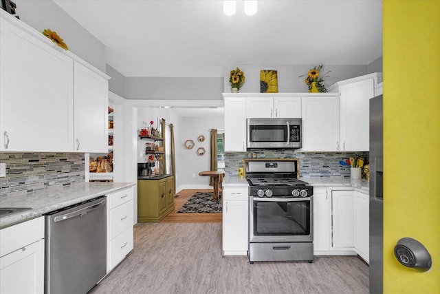 512 S Scarborough St, Sidney, IL 61877 - kitchen featuring appliances with stainless steel finishes, decorative backsplash, white cabinets, and light wood-style flooring