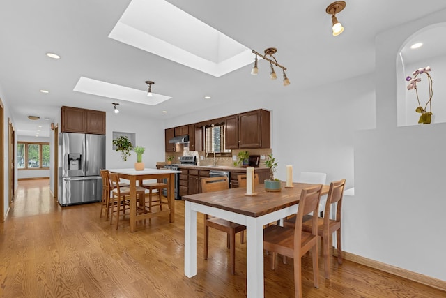 7260 W Fitch Ave, Chicago, IL 60631 - dining area featuring a skylight, light wood-style floors, recessed lighting, and arched walkways