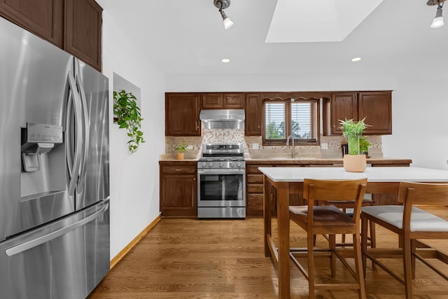 7260 W Fitch Ave, Chicago, IL 60631 - kitchen featuring stainless steel appliances, under cabinet range hood, a skylight, tasteful backsplash, and recessed lighting