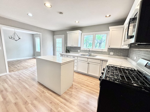 615 N Blanchard St, Wheaton, IL 60187 - kitchen featuring gas range oven, a sink, a center island, tasteful backsplash, and white cabinetry