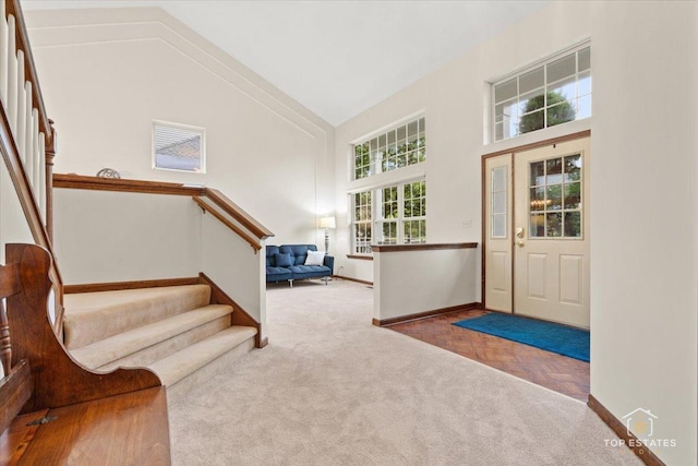 1748 Pinnacle Dr, Aurora, IL 60502 - entrance foyer with a high ceiling, stairs, baseboards, and carpet flooring