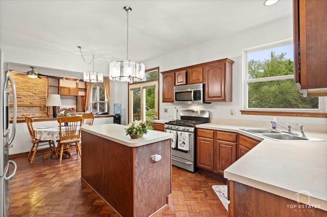 1748 Pinnacle Dr, Aurora, IL 60502 - kitchen featuring appliances with stainless steel finishes, a sink, a chandelier, a kitchen island, and light countertops