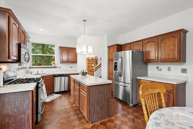 1748 Pinnacle Dr, Aurora, IL 60502 - kitchen featuring appliances with stainless steel finishes, a chandelier, light countertops, a kitchen island, and a sink