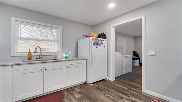 801 Adams St, Oregon, IL 61061 - kitchen with freestanding refrigerator, a sink, washing machine and clothes dryer, dark wood-style floors, and white cabinetry