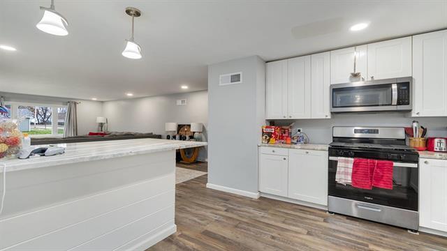 801 Adams St, Oregon, IL 61061 - kitchen featuring appliances with stainless steel finishes, white cabinetry, wood finished floors, hanging light fixtures, and recessed lighting