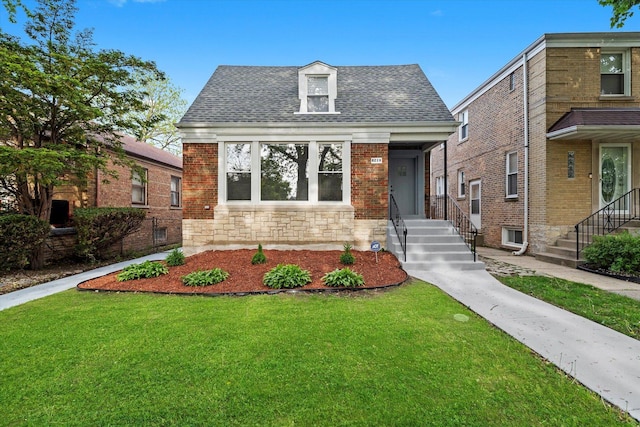 view of front facade featuring a front lawn, roof with shingles, and stone siding