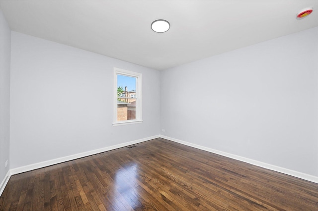 empty room with baseboards and dark wood-style flooring