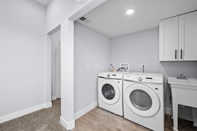 laundry area with washing machine and clothes dryer, baseboards, and a sink