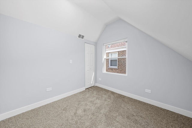 additional living space with vaulted ceiling, carpet flooring, and baseboards