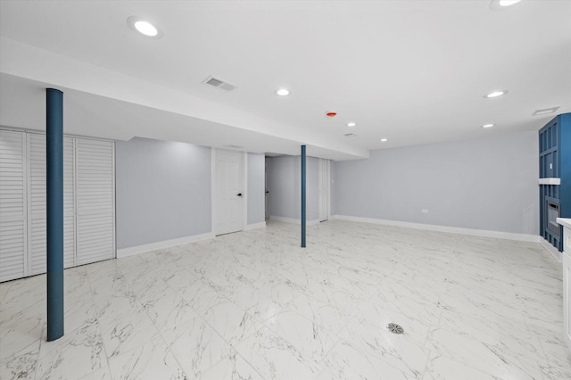 finished below grade area with recessed lighting, baseboards, a fireplace, and light marble finish flooring