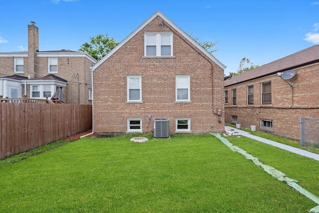 rear view of property featuring central AC and brick siding