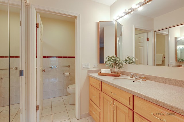 1088 Shermer Rd Unit 307, Northbrook, IL 60062 - full bathroom with tile patterned floors, toilet, tile walls, vanity, and wainscoting