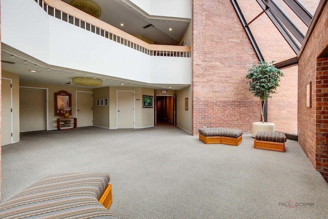 1088 Shermer Rd Unit 307, Northbrook, IL 60062 - common area featuring a towering ceiling, brick wall, and recessed lighting