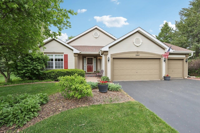 2207 Olde Mill Ln, Mchenry, IL 60050 - view of front of house with driveway, an attached garage, and a front lawn