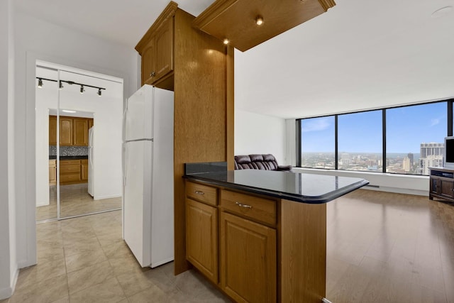5455 N Sheridan Rd Unit 3611, Chicago, IL 60640 - kitchen featuring freestanding refrigerator, dark countertops, brown cabinetry, and open floor plan