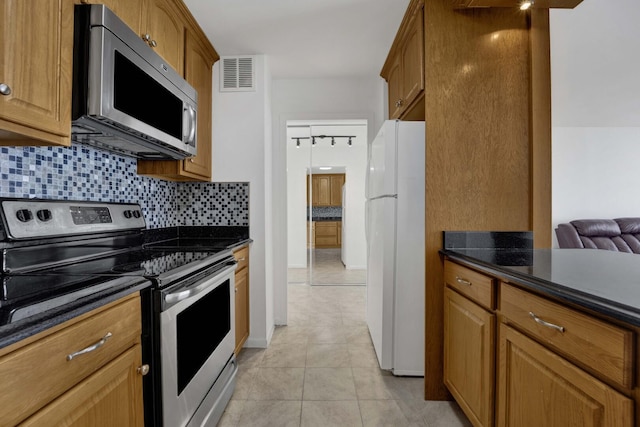 5455 N Sheridan Rd Unit 3611, Chicago, IL 60640 - kitchen featuring stainless steel appliances, tasteful backsplash, light tile patterned floors, and brown cabinets