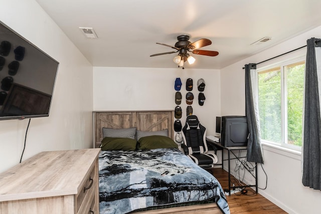 bedroom with wood finished floors, baseboards, and ceiling fan