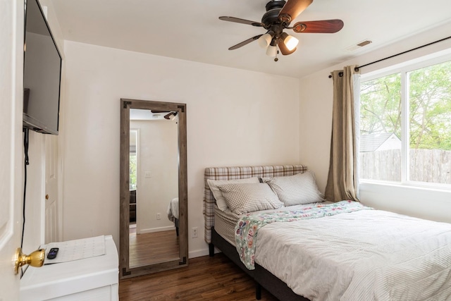 bedroom featuring wood finished floors, baseboards, and a ceiling fan